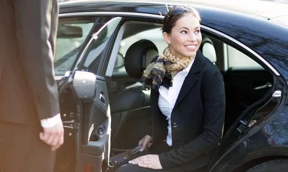 Professional chauffeur opening a luxury vehicle door